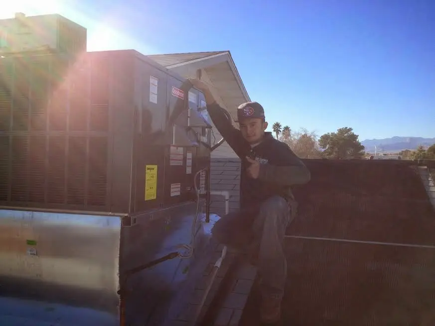 HVAC technician performing Air Duct Repair on a rooftop unit in Mason